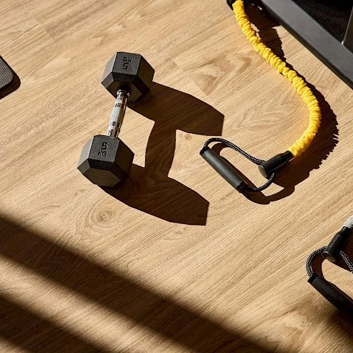 Hanteln und Trainingsband im Fitnessraum