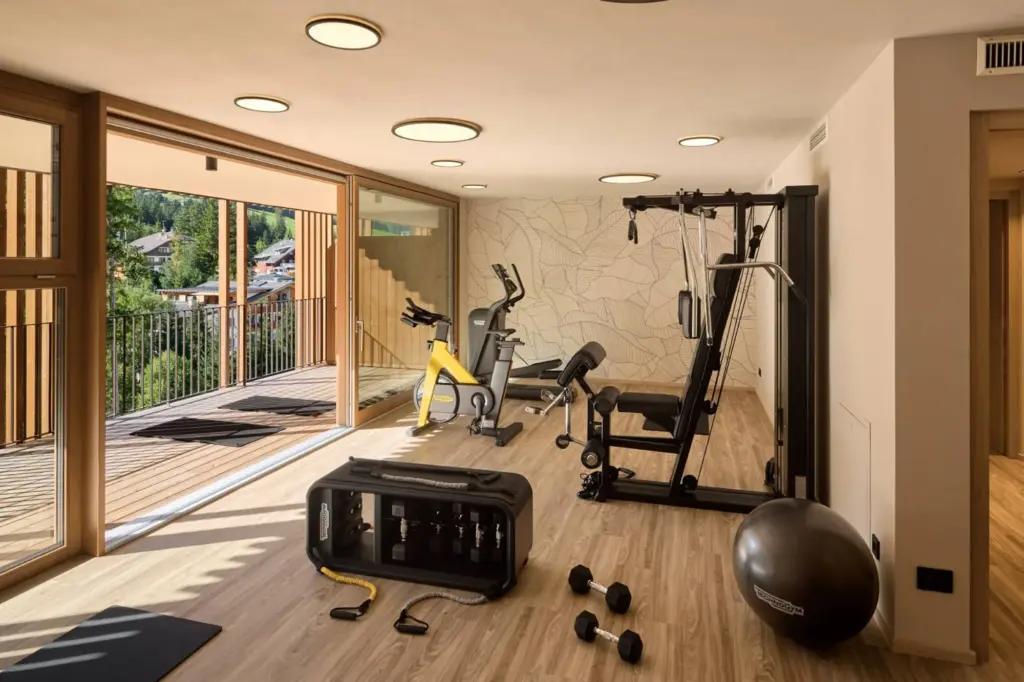 Fitnessraum mit Technogym-Geräten und Blick ins Grüne